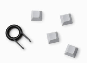 4 Keyzen keycaps in white color with the cap puller